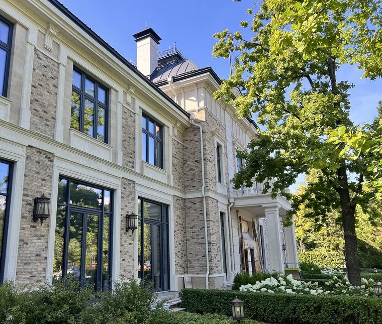 Фасад дома из светлого кирпича с декором тёплого светлого оттенка